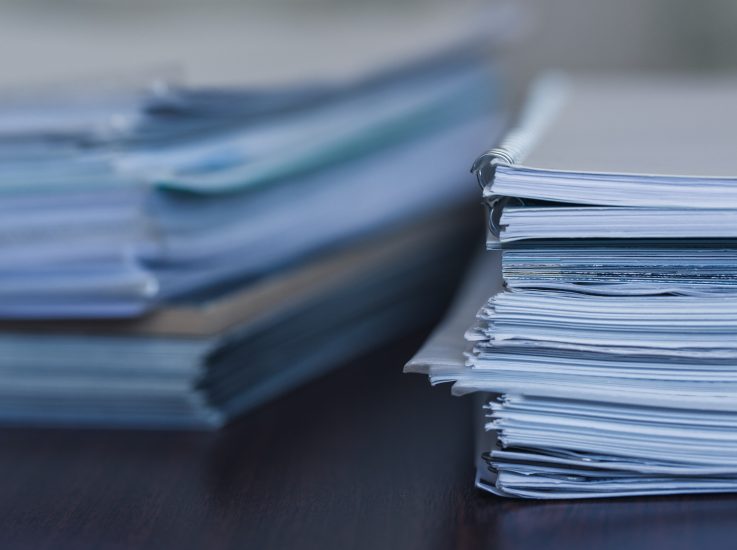 Stack of legal paperwork on a desk, symbolizing the documentation and legal protection provided by non-compete agreements.